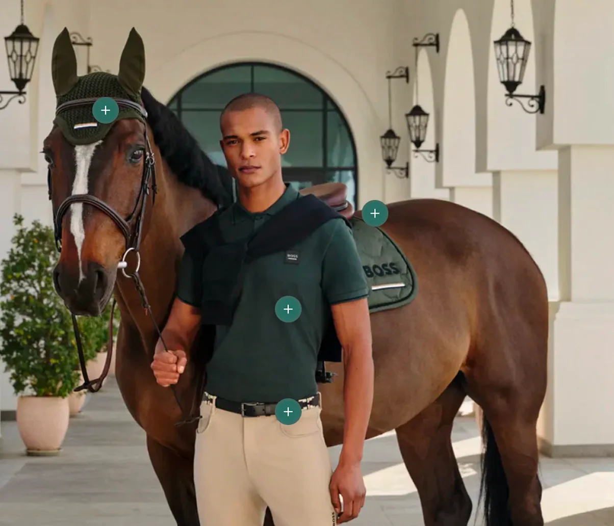 A rider in a green BOSS polo beside his horse, with shoppable hotspots