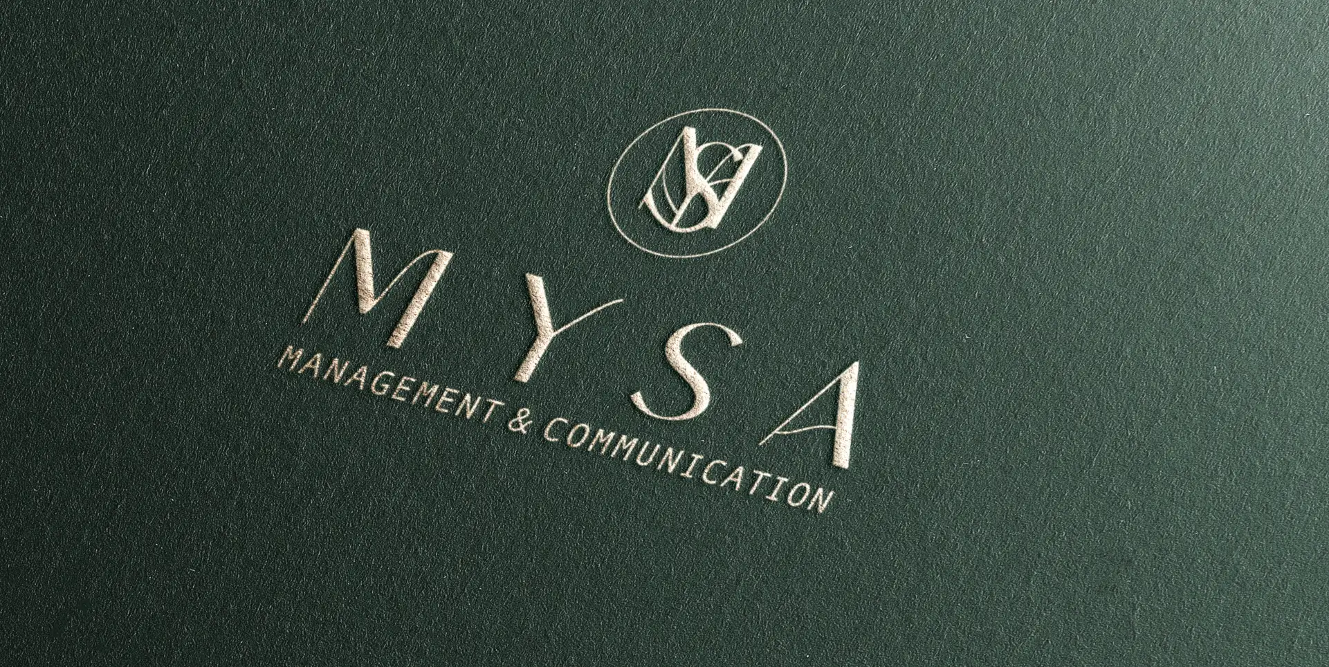 The MYSA monogram and wordmark embossed in pale relief on deep-green textured paper